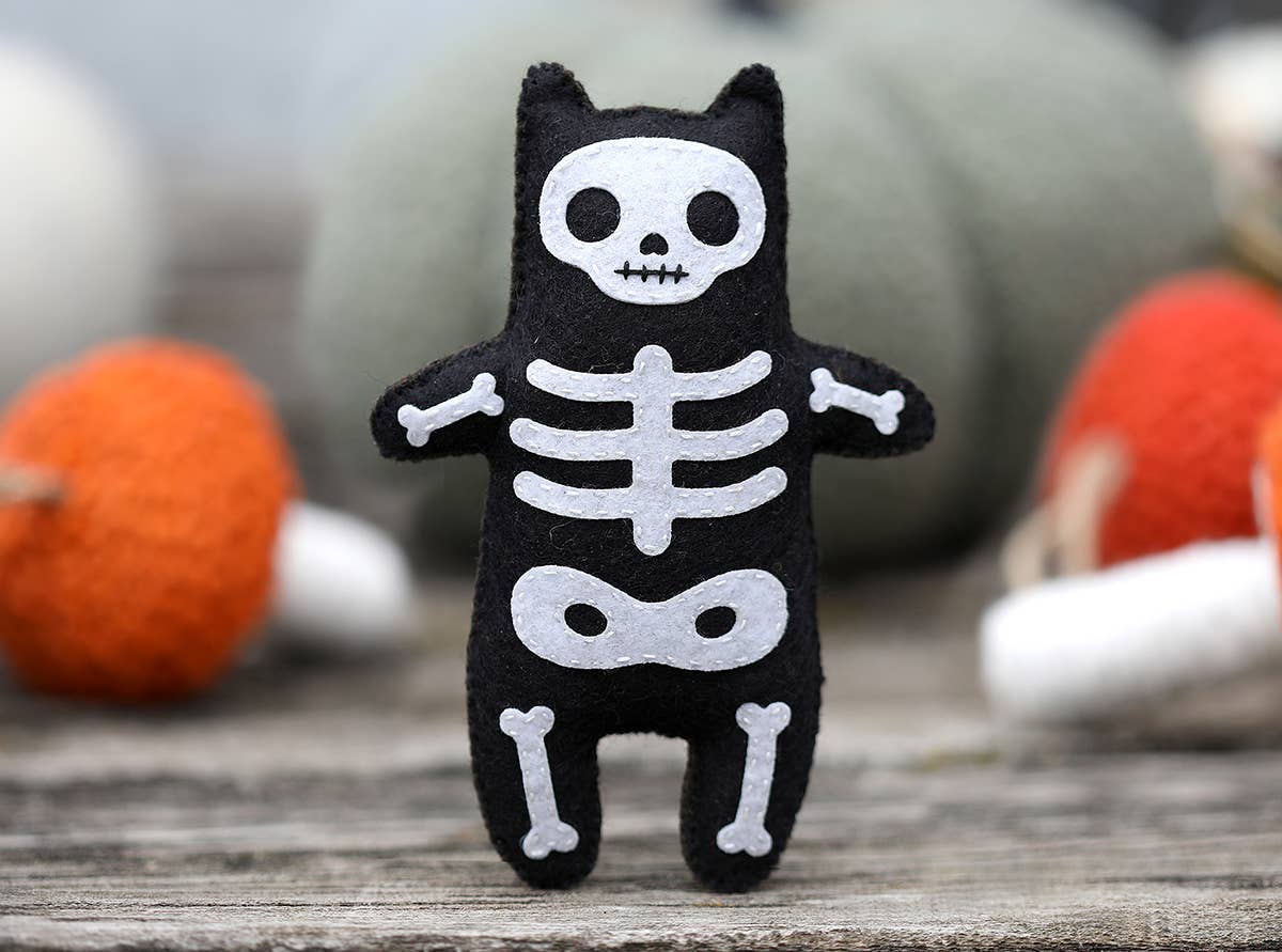 The finished skeleton cat styled alongside felt pumpkins