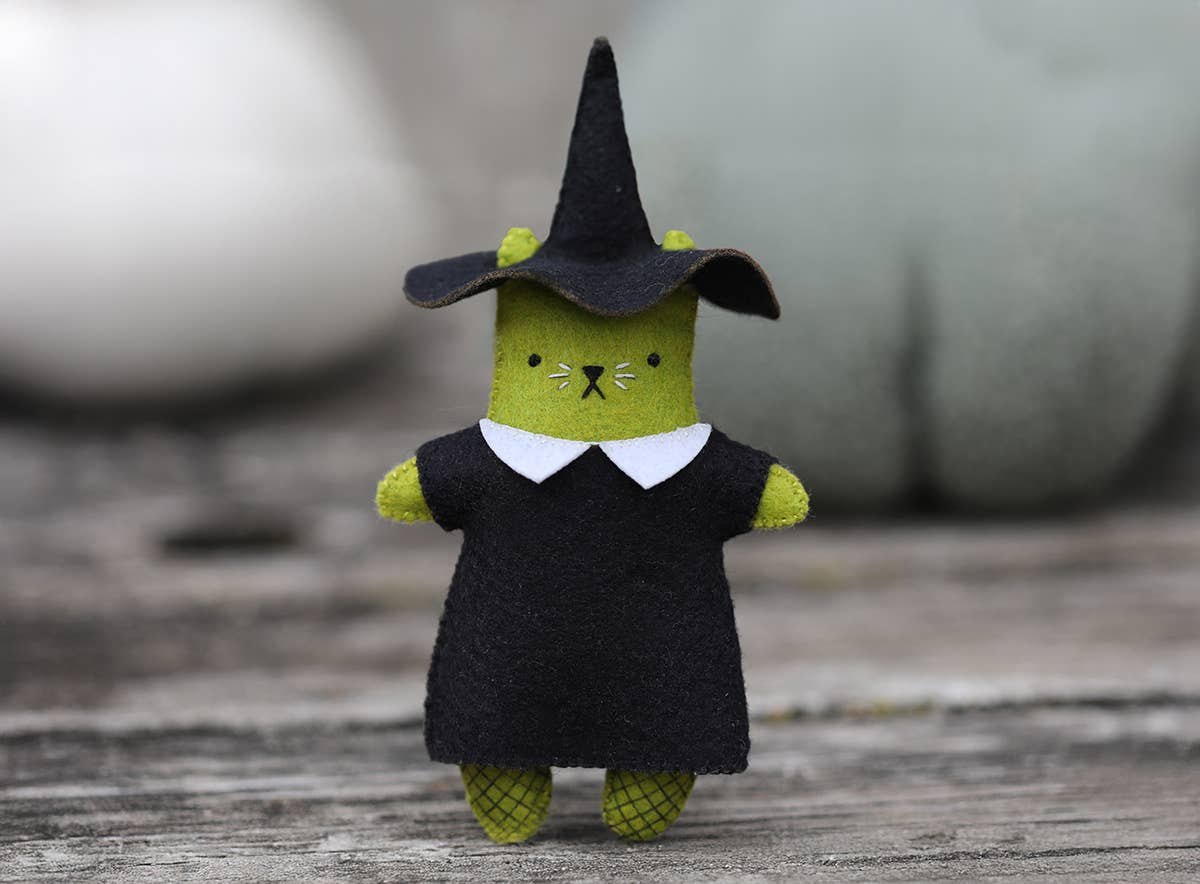 The finished witch cat, white collar and fishnet stockings on green felt
