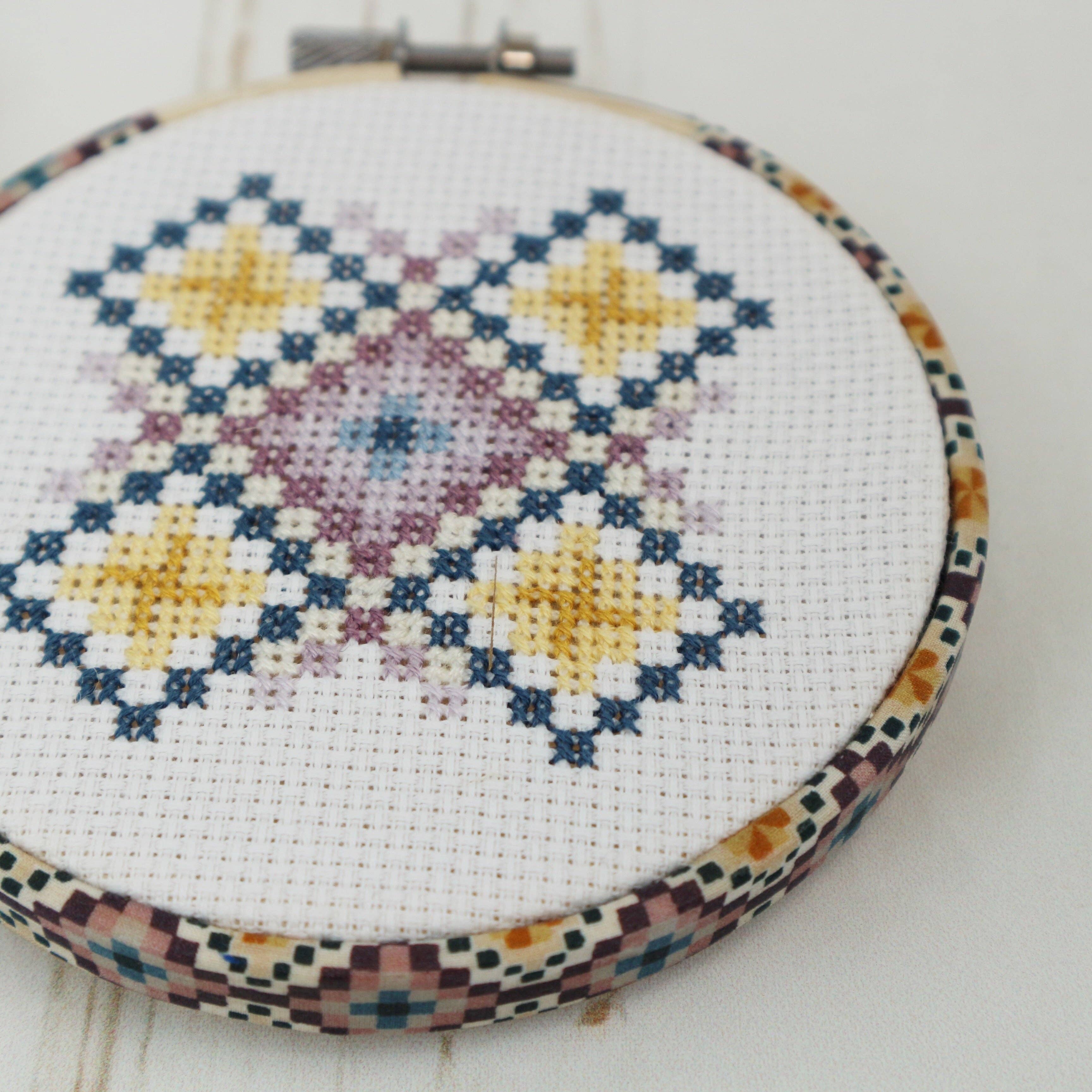 The purple and yellow Liberty Tana Lawn geometric print wrapped around the 4 inch hoop