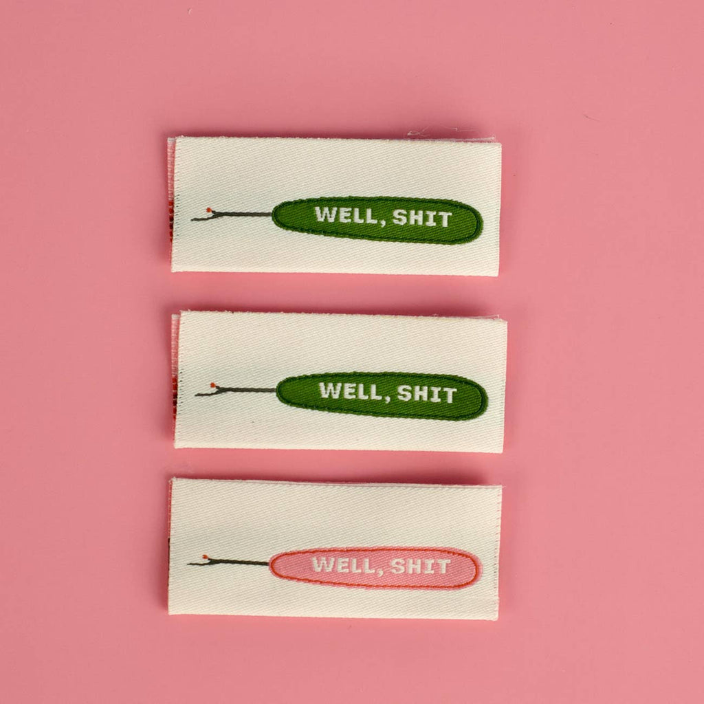 Well Shit woven sew-in label, double sided in pink and green