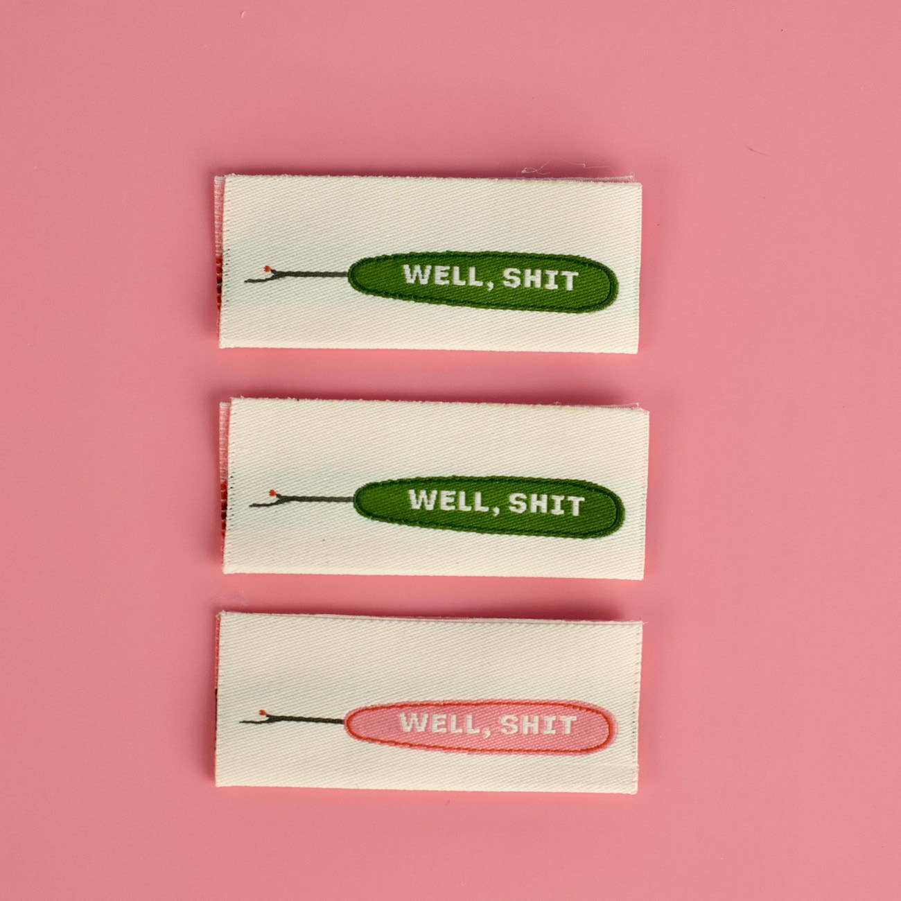 Well Shit woven sew-in label, double sided in pink and green