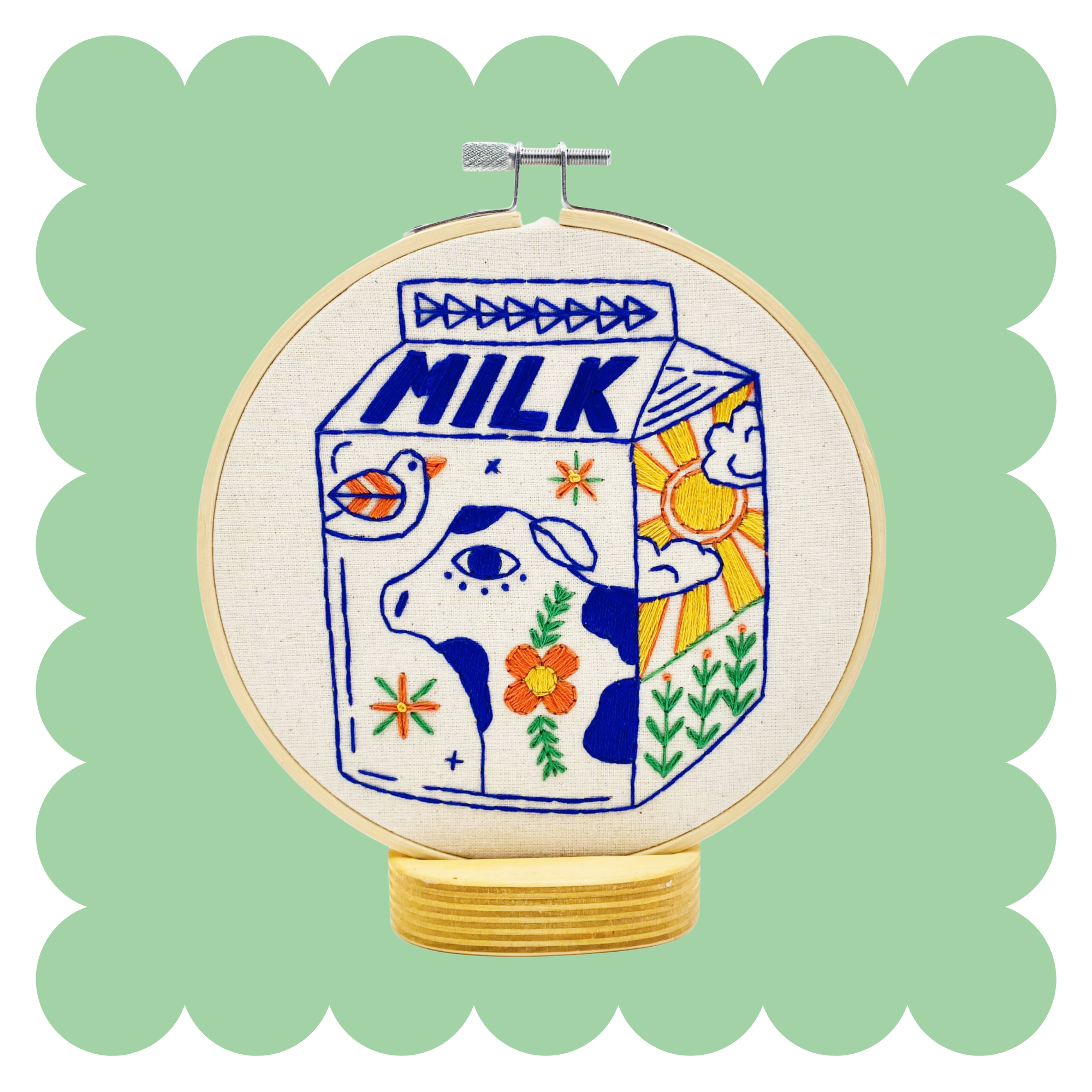 Milk embroidery design on unbleached cotton in a hoop