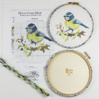 Blue Tit cross stitch kit packaging, listing the chart, aida, threads, needle and wooden back