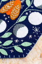 Celestial felt pennant hanging on a wall