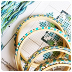 Liberty of London Tana Lawn wrapped hoops in turquoise and green, shown with the cross stitch chart and threads