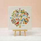 Song of the Seasons cross stitch design featuring birds from four continents on sand colored 14 count aida