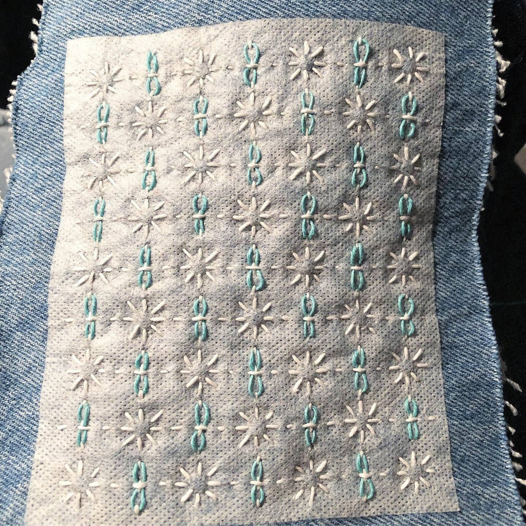 A Set #2 transfer stitched onto a mended garment