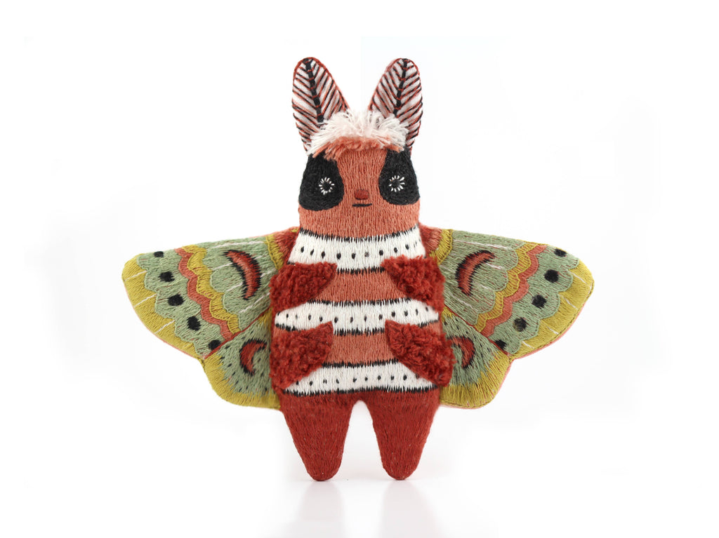 The finished Kiriki Press moth doll, about 4.5 inches tall, densely embroidered and stuffed