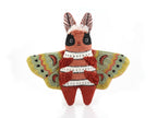 The finished Kiriki Press moth doll, about 4.5 inches tall, densely embroidered and stuffed