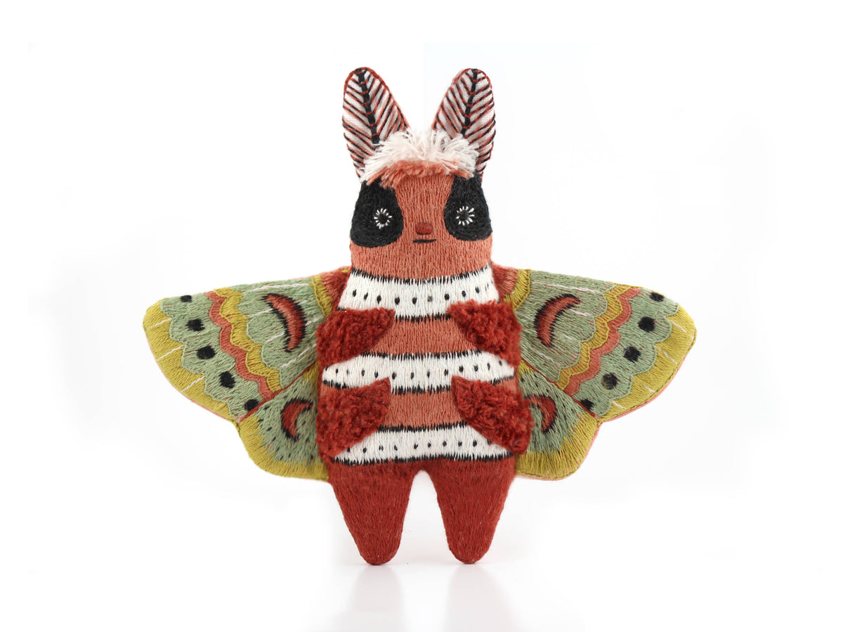 The finished Kiriki Press moth doll, about 4.5 inches tall, densely embroidered and stuffed